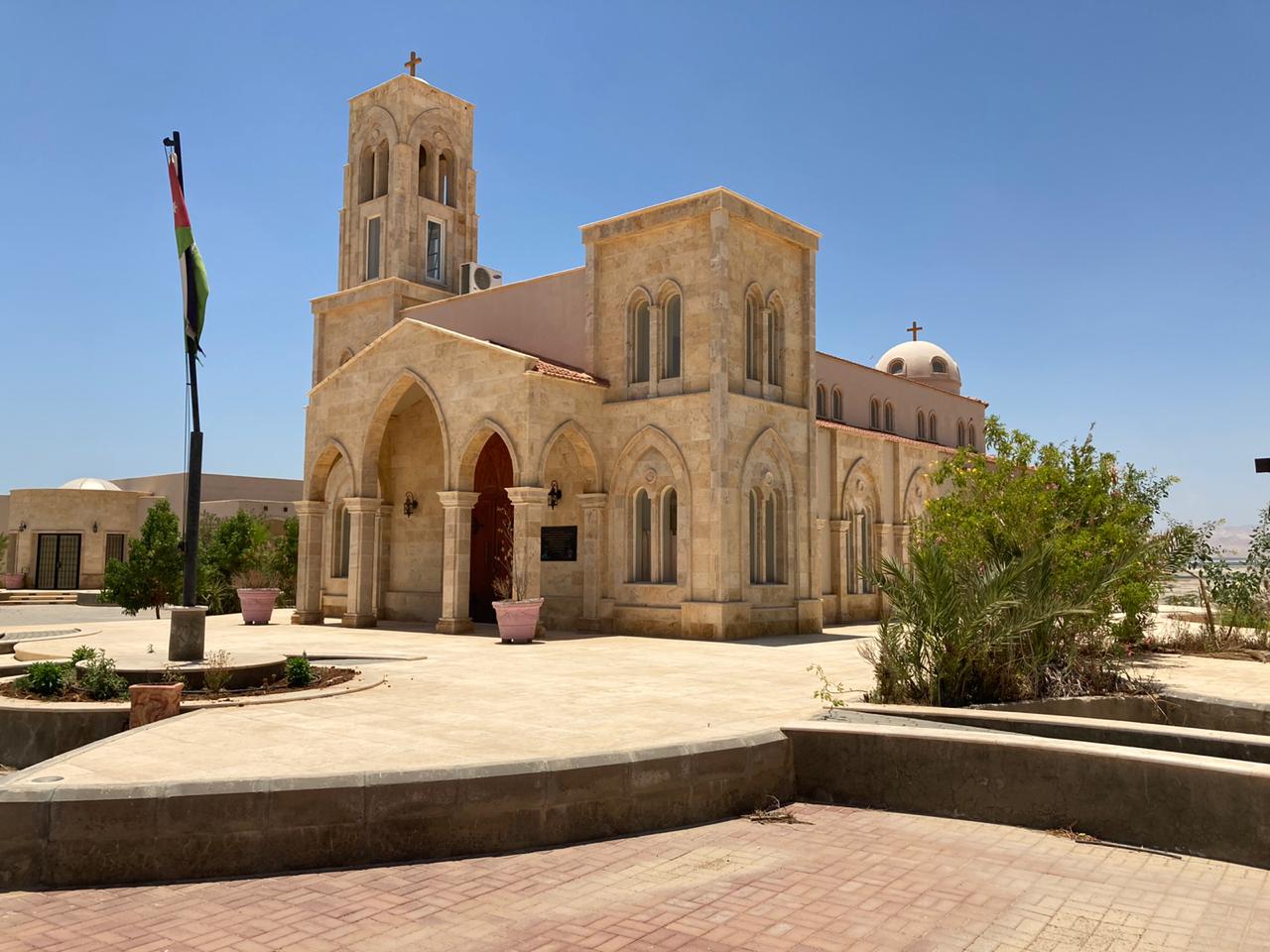 Baptist site church with stone bell tower, arched entry, and desert landscape