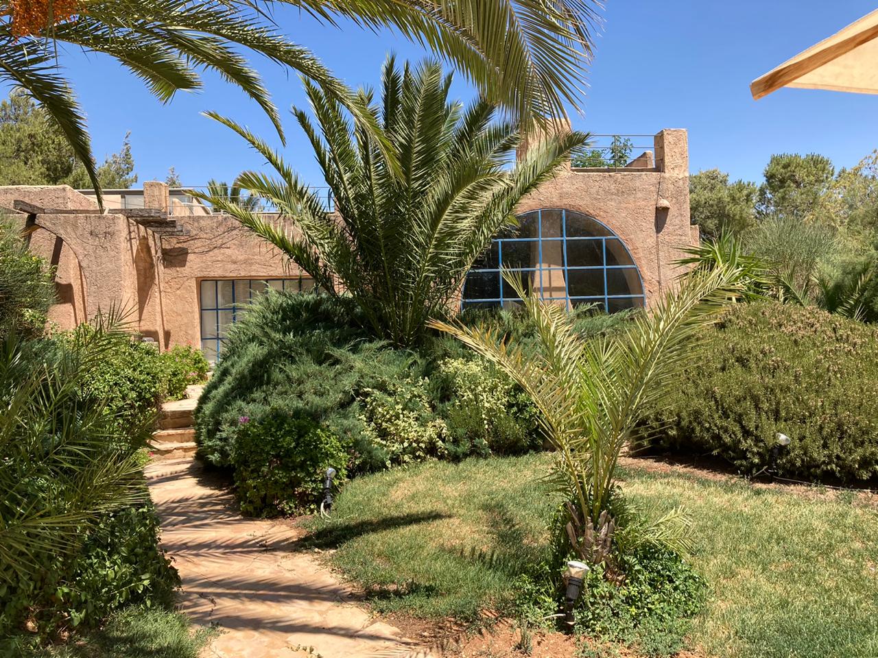 Goussous residence garden path with arched windows and dense planting