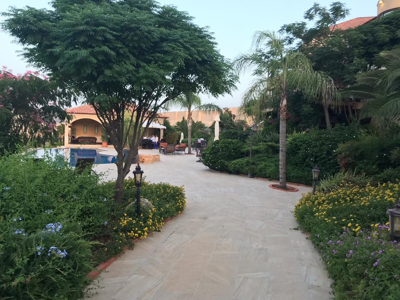 Front driveway view of the Toukan residence with fountain and tiled roof